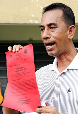 Kg Kerinchi Flat action committee member Mohd Idros Tukiran holding the eviction notice from the Federal Territory Land and Mines Office. KIMBERLY YEO CHUI IN